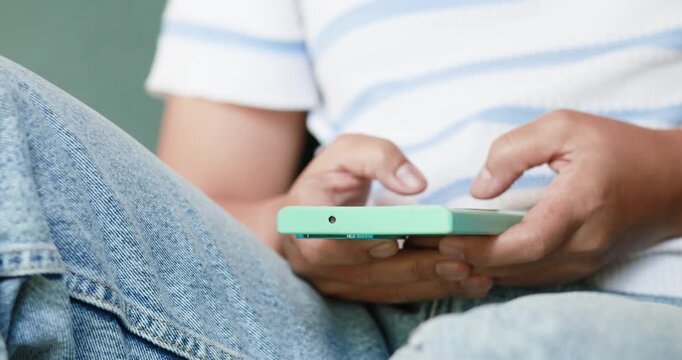 Hands typing and using a smartphone while sitting. Messaging and communication, texting, mobile apps, digital technology, social media, and modern lifestyle concepts, close-up