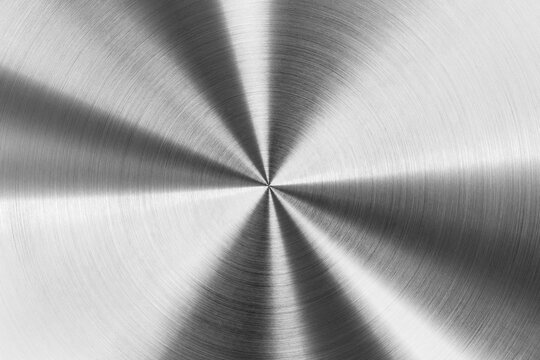 Circular brushed metal texture, silver metallic background macro photography.