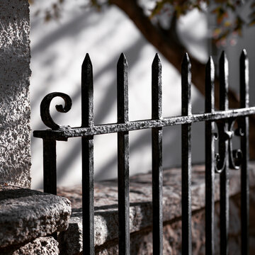 Close-Up of Decorative Black Iron Fence Against White Wall