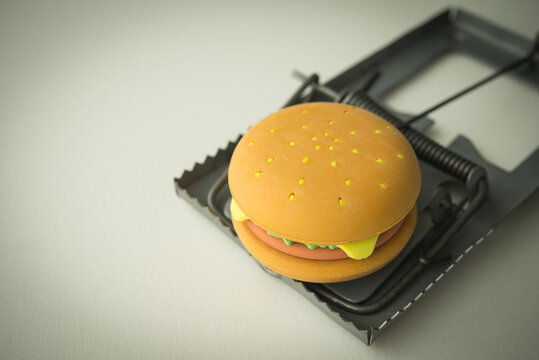 Hamburger fast food in rat trap white background. Junk foods, unhealthy, people office eating lifestyle, exercise concept. Junk foods are full high calories, fat and excess sodium that bad for health.