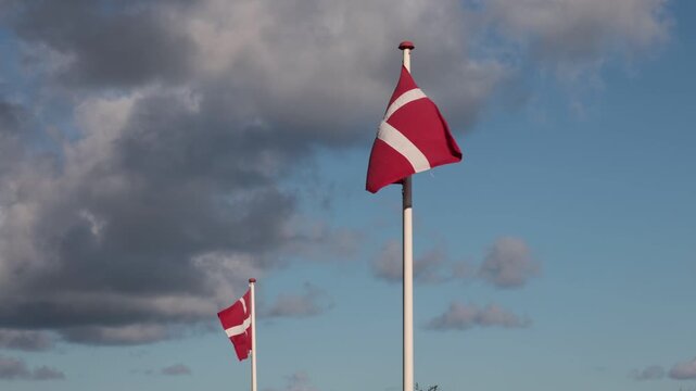 Hirtshals, Denmark A Danish flag flying in the wind on a flagpole. 