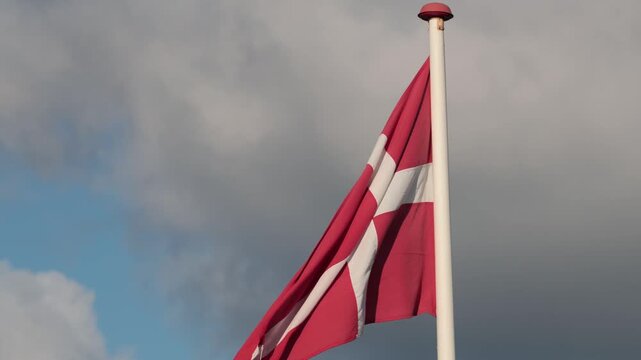 Hirtshals, Denmark A Danish flag flying in the wind on a flagpole. 