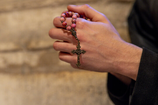 Young man praying with rosary, Paris, France