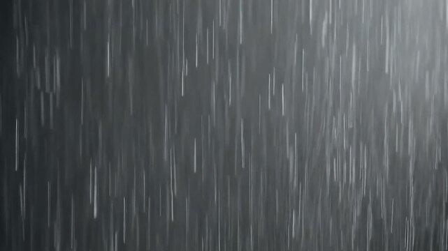 灰色の背景で無数の雨粒が垂直に高速落下し光を反射する水滴と細い雨筋が重なる