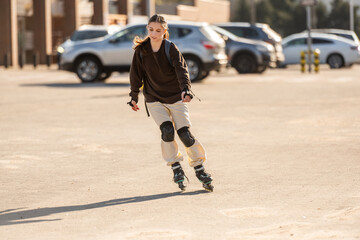 Fototapeta premium Happy Teen Girl Roller Skating In The Parking Lot