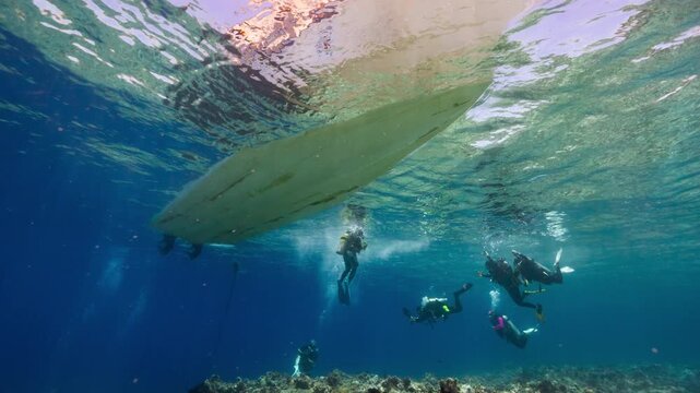 Underwater shot of Dive boat and SCUBA Divers above a reef in the Palau Marine Sanctuary