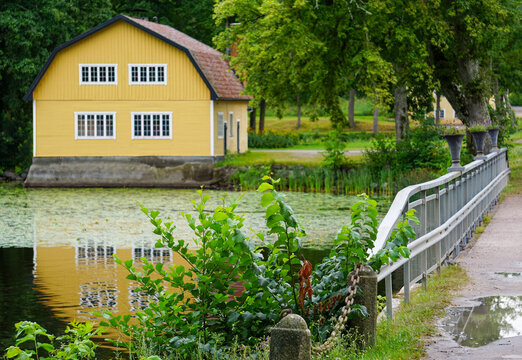 Scenic view of a yellow house by a river in the countryside