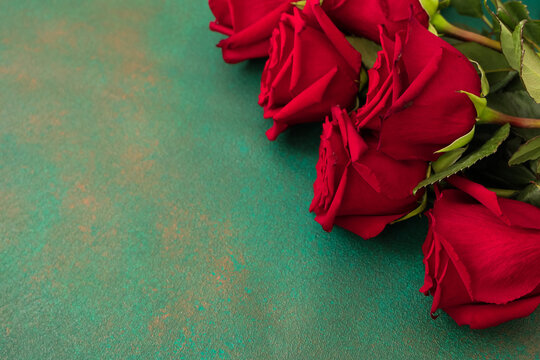 Roses placed on a green surface with visible texture and detail during daytime lighting copy space
