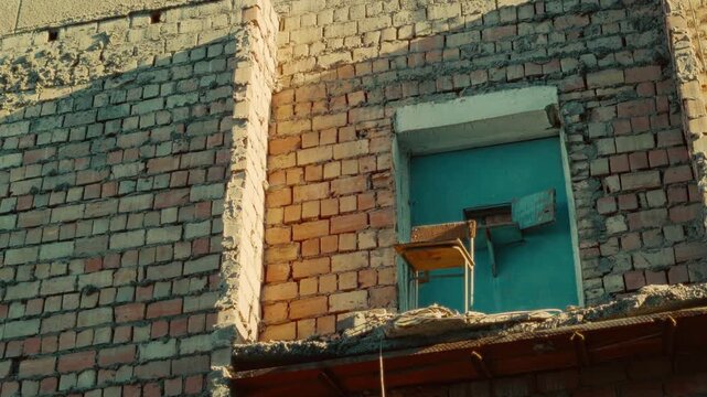 Weathered brick wall featuring a blue door and vintage chair