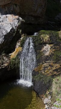 Mountain waterfall flowing into a clear pool in Wasserlochklamm gorge, Palfau, Austrian Alps