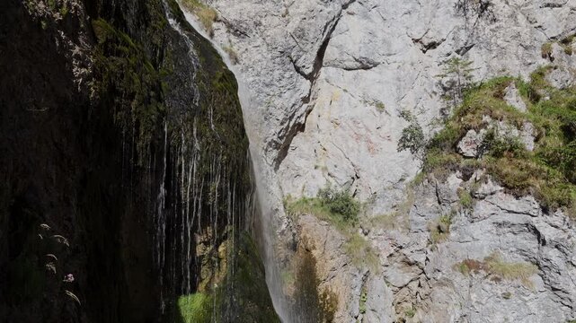 Static shot of Wasserlochklamm waterfall flowing down steep rocks in a mountain gorge in Palfau, Austria