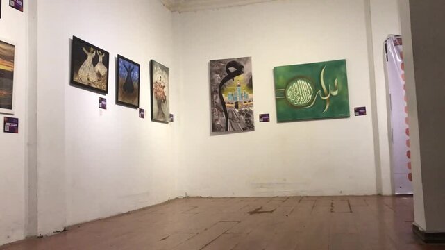 Interior of an empty art gallery with paintings on white walls