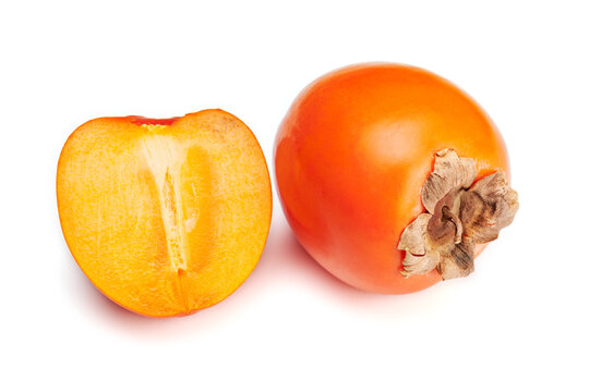 Scene featuring fresh ripe orange persimmon and slice isolated on white background