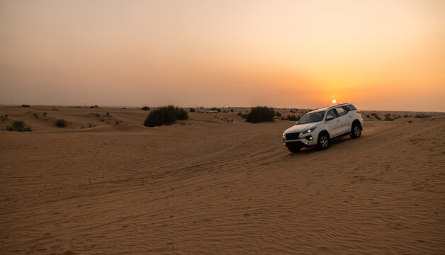 Perfect desert rally white off road vehicle golden desert dunes bright sky. Adventure travel tourism lifestyle design. Sand safari expedition 4x4 scenic wallpaper background copy space