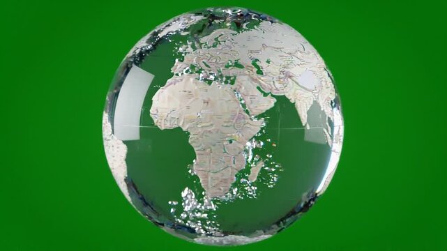 Crystal clear glass globe with rotating world map on vibrant green background