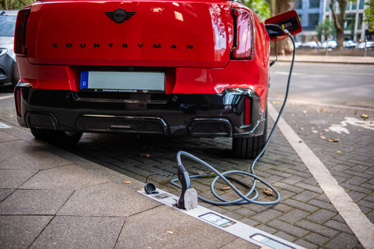 Eine E-Auto wird an einem Ladebordstein auf der K&Ouml; mit einem Kabel aufgeladen, D&uuml;sseldorf, Deutschland