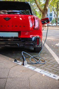 Eine E-Auto wird an einem Ladebordstein auf der K&Ouml; mit einem Kabel aufgeladen, D&uuml;sseldorf, Deutschland