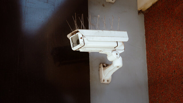 CCTV, camera, security, surveillance, old dirty white security camera with bird spikes mounted on wall