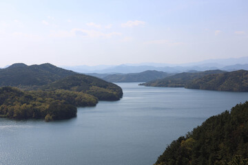 Obraz premium Panoramic High Angle View of Calm Lake Surrounded by Forested Hills and Mountain Ranges