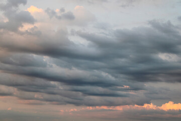 Obraz premium Layered clouds at sunset moody grey skies with golden glow