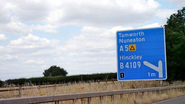 Signpost, road, sign, direction, motorway, UK blue motorway directional signpost showing exit routes for Tamworth, Nuneaton and Hinckley
