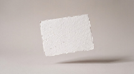 Fototapeta premium Textured handmade paper floating against a neutral background, creating a sense of depth and simplicity