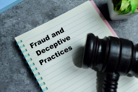 Concept of fraud and deceptive practices write on book isolated on Wooden Table.
