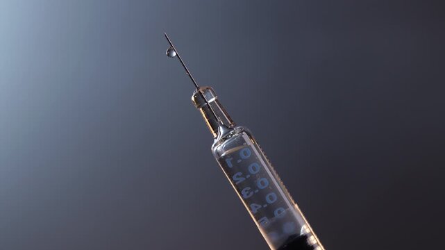 medical syringe deflation until liquid droplet appears on needle tip against white background (version right)