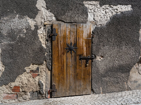 2025-09-03; An old wooden door set in a rough stone wall. Bystrzyca Klodzka. Poland.