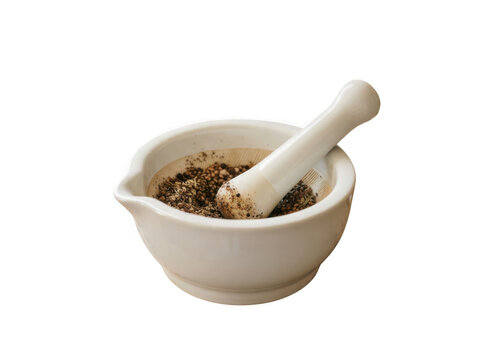 White mortar and pestle with brown spices on wooden surface