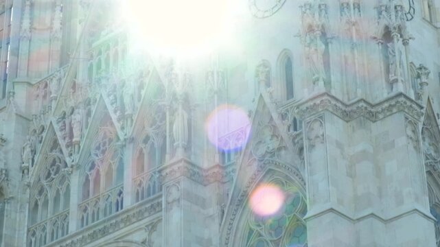 Sun flare over ornate gothic detail of Votivkirche church facade in Vienna