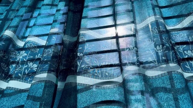 Sunlight Filtering Through Blue Floral Patterned Window Curtain