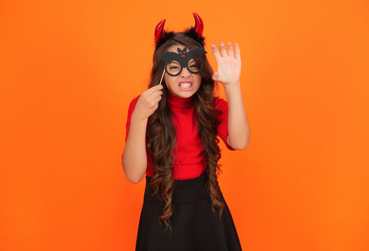 Happy Halloween. Girl devil in Halloween costume isolated on orange. Trick or treat. All Hallows costume party celebration. All Hallows devil. Imp horns. Girl in Halloween imp costume. Devilish look