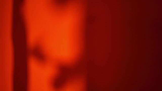 Cinematic silhouette close-up of two anonymous figures making a secretive deal, exchanging a small hidden object followed by a suspicious handshake against a dramatic red background.
