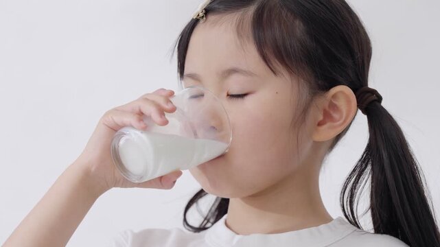 コップで牛乳を飲む子供（健康・身長）