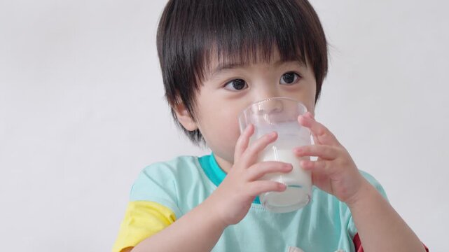 コップで牛乳を飲む子供（健康・身長）