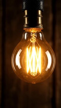 Close up of a vintage edison light bulb glowing in the dark room