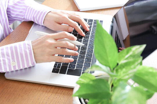 ノートパソコンで作業する女性の手元