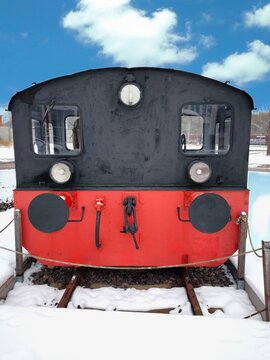 An old black handcar on rails on a winter day on a small town street
