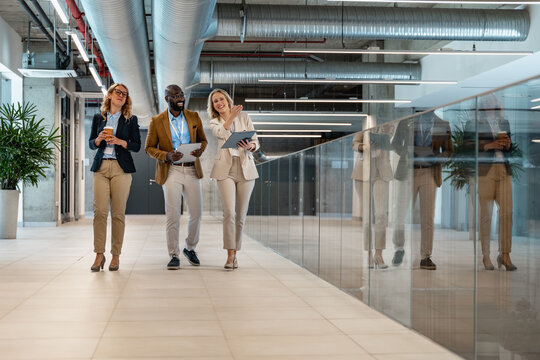 Business team walking in modern office building while discussing project details