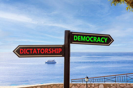 Democracy or dictatorship words symbol. Concept words Democracy Dictatorship on beautiful black road sign. Beautiful blue sky background. Business democracy dictatorship concept. Copy space