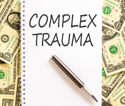 Complex trauma words symbol. Concept words Complex trauma on beautiful white note. Beautiful dollar bills background. Dollar bills. Psychological complex trauma support concept. Copy space.