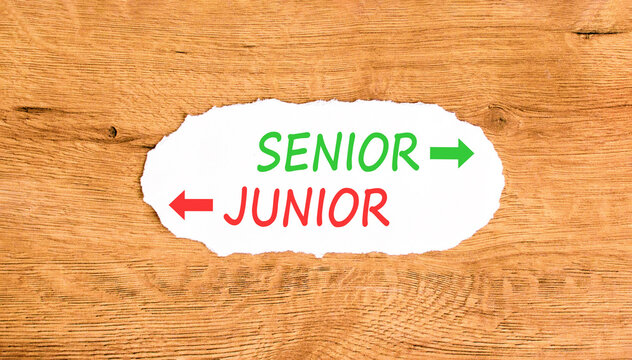 Senior or junior words symbol. Concept words Senior Junior on beautiful white paper. Beautiful wooden background. Business and senior or junior concept. Copy space.