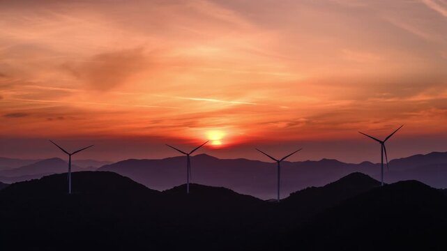 Wind Turbines Silhouetted Against a Golden Sunrise Over Mountain Ridges, Timelapse of Wind Farm at Dawn	
