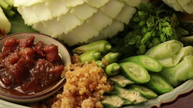Traditional Thai spicy shrimp paste dip set (Nam Prik Kapi) beautifully arranged with intricately carved vegetables, fried acacia omelet, and side dishes, Bangkok, Thailand