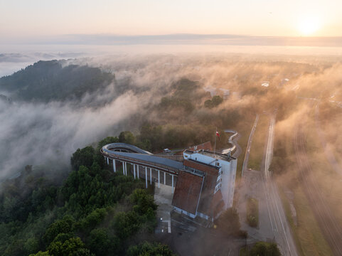 Aerial view of Sigulda bobsleigh track at golden sunrise with morning fog in Gauja National Park Latvia