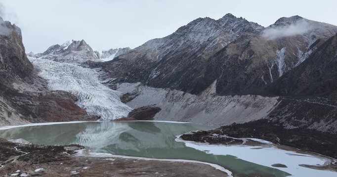 Beautiful high altitude hanging glacier and snow capped mountain with lake in Tibet, China