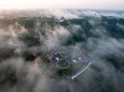 Aerial view of the Sigulda bobsleigh and luge track surrounded by morning fog at sunrise in Gauja National Park, Latvia