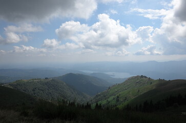 Fototapeta premium Panoramic view of rolling green hills under a cloudy sky