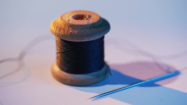 Black thread with needle on white table